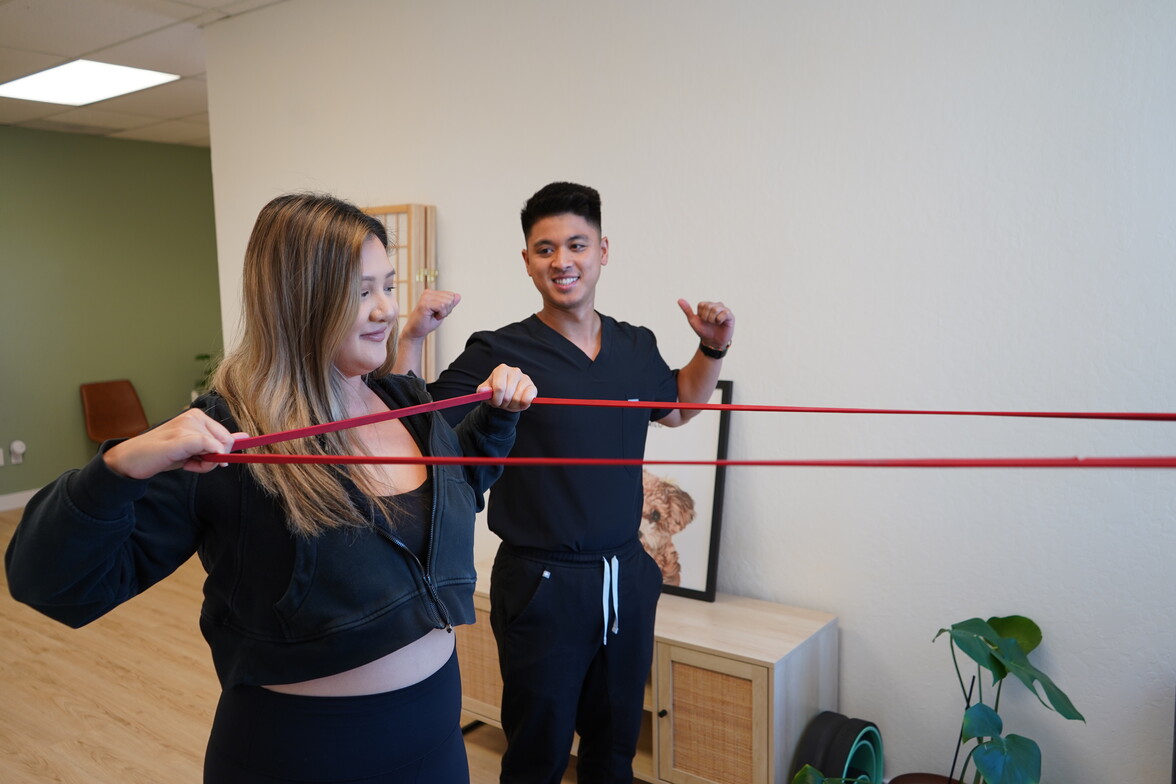 Dr. Daniel Cagape coaching a patient through a resistance band row at Modern Movement Chiropractic in Milpitas